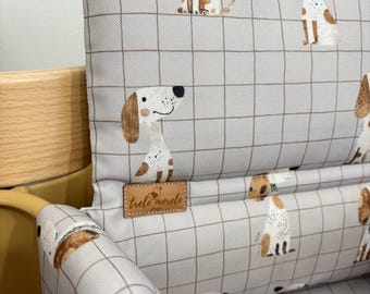 May include: A gray and white high chair cushion with a dog pattern. The cushion has a brown label that says "trele morle shop".