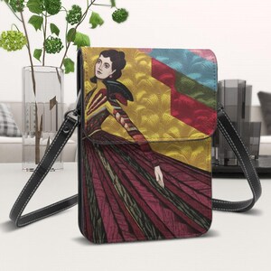 May include: A black leather crossbody bag with a colorful illustration of a woman in a long dress. The illustration features geometric shapes and a yellow background.