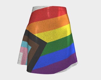 May include: A rainbow pride flag skirt with a black triangle in the center. The skirt is made of a sparkly fabric.