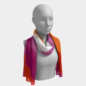 May include: A colorful scarf draped on a mannequin. The scarf features a design with shades of orange, white, and pink. The scarf is made of a lightweight material and is draped around the mannequin's neck and shoulders.