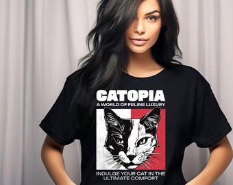 May include: A black t-shirt with a white graphic design featuring a cat's face and the text "Catopia, A World of Feline Luxury, Indulge Your Cat in the Ultimate Comfort."
