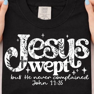 May include: A white ceramic mug with a black handle and the text "But First, Coffee" in a black, handwritten-style font. The mug is on a white surface.