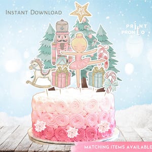 Può includere: Una torta rosa e bianca con un  cavatappi, una ballerina, un cavallo a dondolo e un topper per l'albero di Natale. La torta è decorata con glassa rosa e fiocchi di neve. I topper sono stampati su cartoncino e sono pronti per essere ritagliati e assemblati.