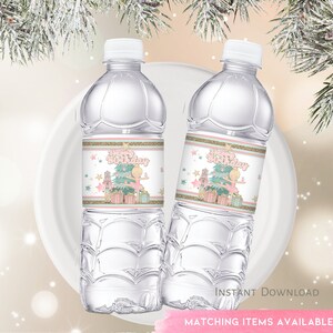 May include: Two clear plastic water bottles with labels featuring a pink ballerina, a Christmas tree, and the text "Happy Birthday". The labels have a gold glitter background and white stars.