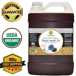 Puede incluir: Una jarra de un gal&oacute;n de aceite de semilla negra org&aacute;nico extra virgen Pure Glory. La etiqueta es marr&oacute;n con detalles dorados y presenta una semilla de comino negro. La etiqueta tambi&eacute;n indica "Comino negro/Nigella Sativa" y "32oz/960ml".