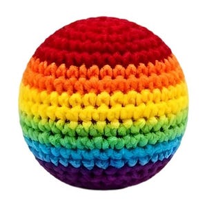 Könnte beinhalten: Ein kugelförmiger Ball aus gehäkeltem Garn mit horizontalen Streifen in einer leuchtenden Regenbogenfarbfolge. Das Muster verläuft von Rot an der Oberseite über Orange, Gelb, Grün und Blau bis hin zu einem tiefen Violett an der Unterseite.