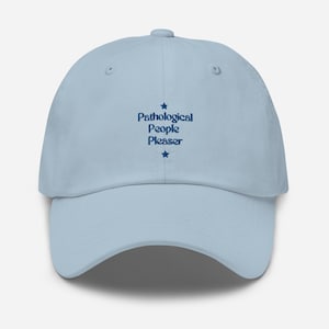 Puede incluir: Una gorra de béisbol azul claro con el texto "Pathological People Pleaser" bordado en azul oscuro con una estrella arriba y abajo del texto.