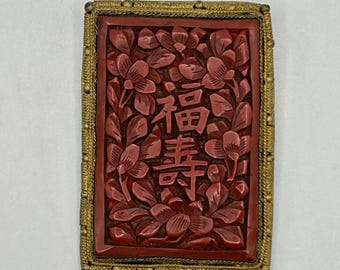 Broche único de cinabrio de la década de 1920 con caracteres chinos tallados rodeados de flores - Montura y respaldo de latón - Marcado como China