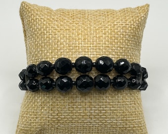 Pulsera de luto de estilo victoriano neorrenacentista: cuentas de vidrio negro de doble hebra, talladas en facetas y graduadas, ensartadas en alambre con memoria, circa 1940.