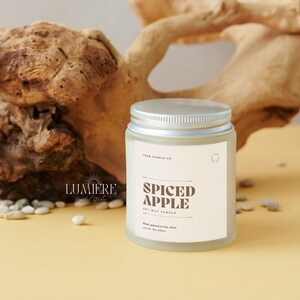 May include: A frosted glass jar candle with a silver lid. The label reads "Four Candle Co." and "Spiced Apple Soy Wax Candle".