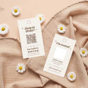 May include: Two white cards with brown text on a light brown fabric background with white daisies. The first card has a QR code and the text "Scan to Order!" and "You Candle Co." The second card has the text "I'm scented!" and "SCENT NAME ORANGE | GRAPEFRUIT | LIME | CITRUS YOUR CANDLE CO www.yourwebsite.com"