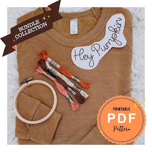 Peut inclure: Un sweat-shirt marron avec le texte "Hey Pumpkin" et du fil à broder dans les tons orange, marron et rose. Un cercle à broder et un graphique "Printable PDF Pattern" sont également visibles. L'image fait partie d'une "Bundle Collection".