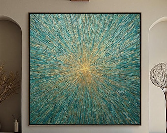 May include: Large abstract wall art with a teal and gold burst design. The artwork is framed in black and hangs above a dark wood bench. The room features a white sofa, a gold side table, and a decorative floor lamp.