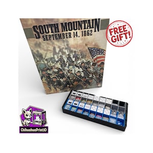 May include: A board game box titled "South Mountain September 14, 1862" with an illustration of soldiers and an American flag. A black tray with game pieces is in front of the box. A "Free Gift!" sticker is visible.