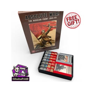 Puede incluir: Una caja de juego de mesa titulada "ABSOLUTE WAR! THE RUSSIAN FRONT 1941-45" con un gráfico de un soldado sosteniendo una bandera. La caja es marrón y las piezas del juego están en una bandeja negra. Una pegatina "FREE GIFT!" es visible.