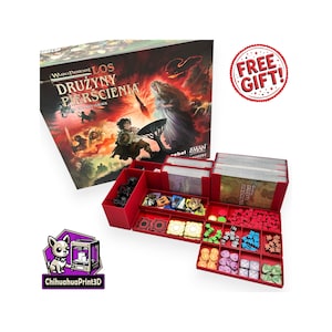 May include: A board game box titled Wladca Pierscieni Los Druzyny Pierscienia with a red plastic organizer insert. The insert contains various colored game tokens, small character figures, and card decks. A circular red sticker reads FREE GIFT.