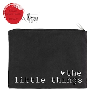 May include: Black canvas zipper pouch with white text that reads "little things" and a small heart symbol. The pouch is 10 inches by 7.5 inches.