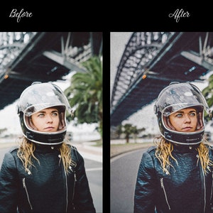 May include: A woman wearing a black leather jacket and a clear motorcycle helmet with a dark visor stands in front of a bridge. The helmet has a brown leather trim around the edge.