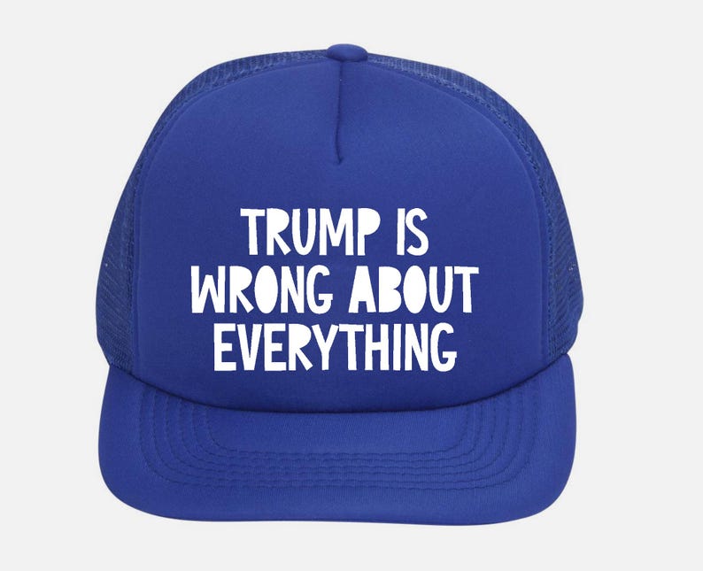 May include: A royal blue trucker hat with a white mesh back and a curved brim. The front of the hat features the white text "TRUMP IS WRONG ABOUT EVERYTHING".