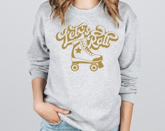 May include: A gray sweatshirt with the text "Let's Roll" in gold lettering and a gold silhouette of a roller skate.
