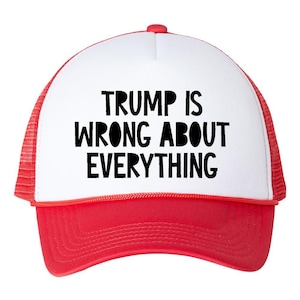 May include: A red and white trucker hat with the text "TRUMP IS WRONG ABOUT EVERYTHING" in bold black letters. The hat has a white front panel, a red brim, and a red mesh back.