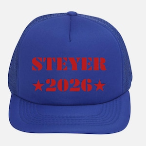 May include: A blue trucker hat with a mesh back and a curved brim. The front of the hat features the red text "STEYER 2026" with two red stars. The hat is a classic style, suitable for casual wear.