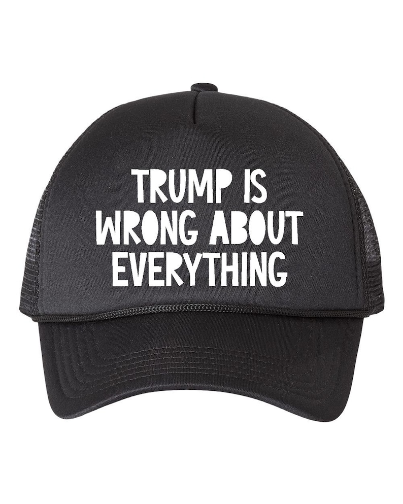 May include: Black trucker hat with white text that reads "TRUMP IS WRONG ABOUT EVERYTHING." The hat has a curved brim and a mesh back.