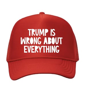 May include: Red trucker hat with white text that reads "TRUMP IS WRONG ABOUT EVERYTHING". The hat has a mesh back and a curved brim. A political statement.