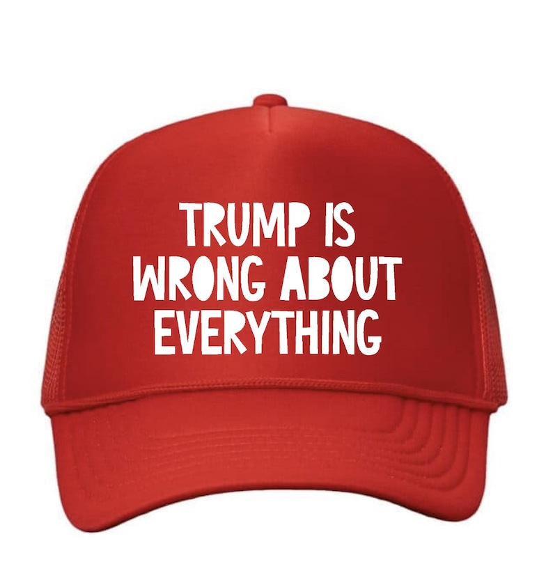 May include: Red trucker hat with white text that reads "TRUMP IS WRONG ABOUT EVERYTHING". The hat has a mesh back and a curved brim. A political statement.