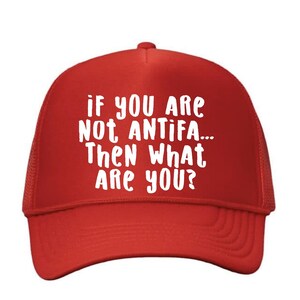 May include: Red trucker hat with white text that reads: "If you are not ANTIFA... Then What Are You?" The hat has a mesh back and a curved brim.
