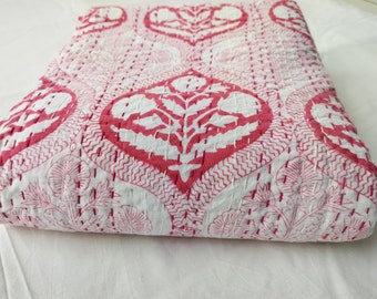 May include: A white cotton quilt with a pink floral pattern. The quilt is hand-stitched and has a traditional Indian design.