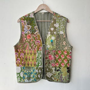 Może przedstawiać: Zielona pikowana kamizelka z patchworkowym wzorem z kwiatowymi motywami. Kamizelka ma dekolt w kształcie litery V i podszewkę w paski.