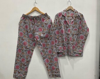 May include: A gray pajama set with a floral pattern in pink and brown. The set includes a button-down shirt and drawstring pants. The shirt has white trim and the pants have a relaxed fit.