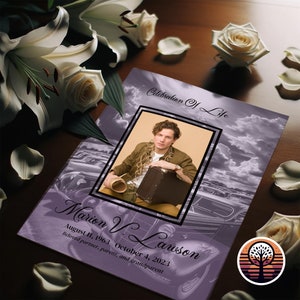 May include: A purple and white memorial card with a photo of a man in a brown shirt and a suitcase. The text reads "Celebration of Life" and "Marion V. Lawson August 11, 1963 October 4, 2023 Beloved partner, parent, and grandparent".