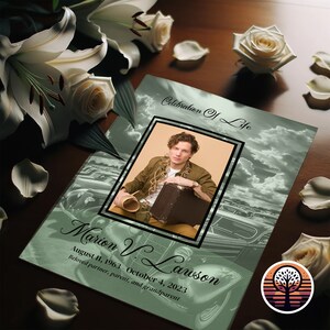 May include: A green and white memorial card with a photo of a man in a brown shirt and a suitcase. The card has the text "Celebration of Life" and "Marion V. Lawson" with dates of birth and death. A stylized tree with a sunset background is in the lower right corner.