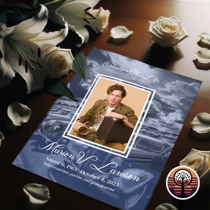 May include: A blue and white memorial card with a photo of a man in a brown jacket and a suitcase. The text reads "Celebration of Life" and "Marion V. Lawson, August 11, 1963 - October 4, 2023, Beloved partner, parent, and grandparent".