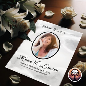 May include: A white memorial card with a black border and a photo of a woman smiling. The text reads "Celebration of Life" and "Marion V. Lawson August 11, 1963 - October 4, 2023 Beloved wife, mother and grandmother".