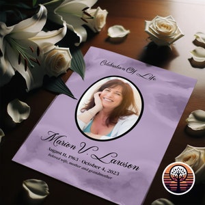 Op de afbeelding: Een paars en wit gedenkboekje met een foto van een lachende vrouw. De tekst luidt "Celebration of Life" en "Marion V. Lawson 11 augustus 1963 - 4 oktober 2023 Geliefde vrouw, moeder en grootmoeder".