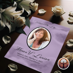 May include: A purple and white memorial booklet with a photo of a woman smiling. The text reads "Celebration of Life" and "Marion V. Lawson August 11, 1963 - October 4, 2023 Beloved wife, mother and grandmother".