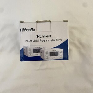 May include: A white cardboard product box for a Tiffcofio brand indoor digital programmable timer, SKU MH-270. The packaging features the brand name, product name, and two images of the white rectangular timer with a digital display and buttons.