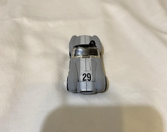 Coche de juguete Hot Wheels Shelby Cobra 427 S/C gris con franja blanca y capó abierto de 29 pulgadas, fabricado en metal fundido a presión.