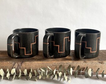 Black handmade ceramic mug with abstract geometric line