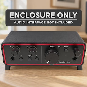Puede incluir: Una carcasa rectangular negra para interfaz de audio con un borde rojo. El panel frontal presenta perillas, botones y el texto Scarlett Solo. Una pancarta negra arriba dice ENCLOSURE ONLY AUDIO INTERFACE NOT INCLUDED.