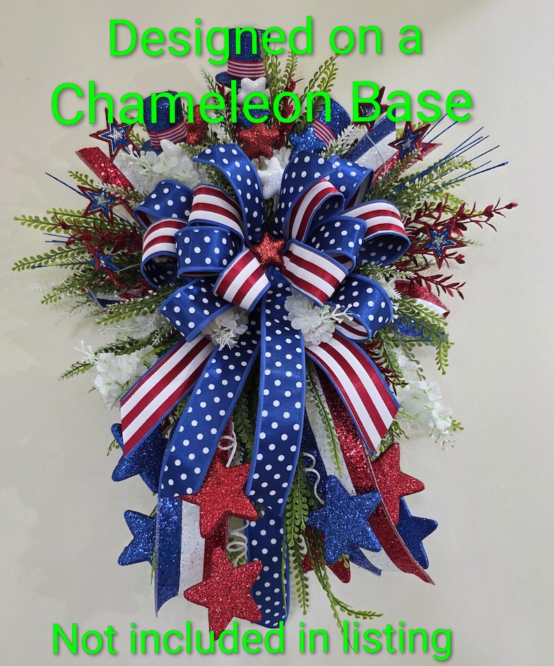 K&ouml;nnte beinhalten: Ein patriotischer Kranz mit rot-wei&szlig;-blauen B&auml;ndern in Punkt- und Streifenmustern, verziert mit glitzernden Sternen und gr&uuml;nem Blattwerk. Der Text 'Designed on a Chameleon Base' und 'Not included in listing' ist sichtbar.
