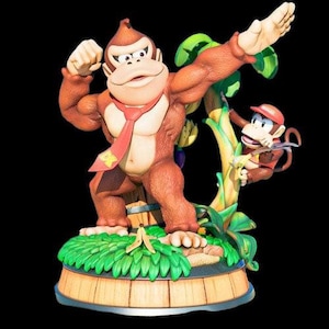 Könnte beinhalten: Eine braune und beige Donkey Kong Figur mit roter Krawatte, die auf einem Holzsockel mit grünen Blättern steht. Eine kleinere braune und beige Diddy Kong Figur klettert an einer Rebe hinter Donkey Kong.