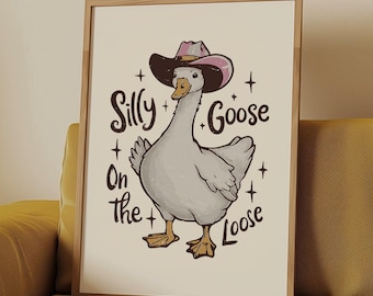 May include: A white goose wearing a pink and black cowboy hat with the text "Silly Goose On The Loose" printed on a white background.