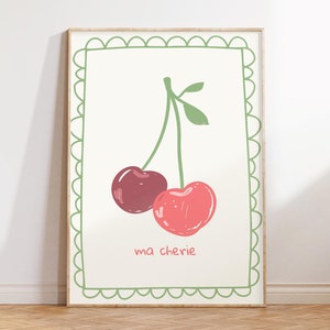May include: A green framed print with a white background featuring a drawing of two red cherries on a stem with green leaves. The text "ma ch&eacute;rie" is written below the cherries.