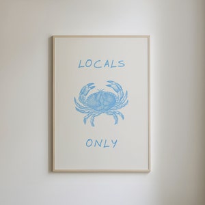 May include: A framed print with a blue crab illustration and the text "LOCALS ONLY" in blue.