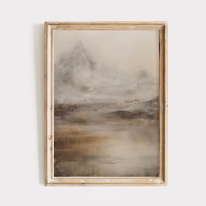 May include: A framed painting depicting a misty mountain landscape with a lake in the foreground. The painting is rendered in muted tones of brown, grey, and white.