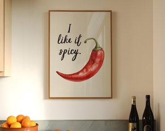 May include: A framed print with a red chili pepper and the text "I like it spicy."  The print is hanging on a wall in a kitchen with a marble countertop and a bowl of oranges.